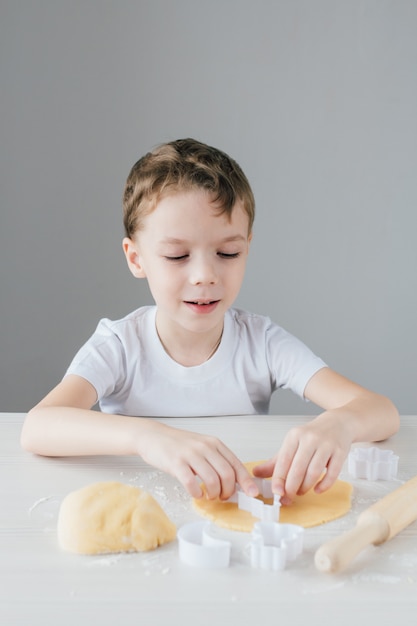 El niño prepara galletas navideñas caseras