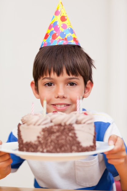 Foto niño presentando pastel de cumpleaños