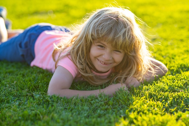 Niño de primavera cara sonriente niño niño con fondo de hierba retrato de un niño pequeño feliz en su