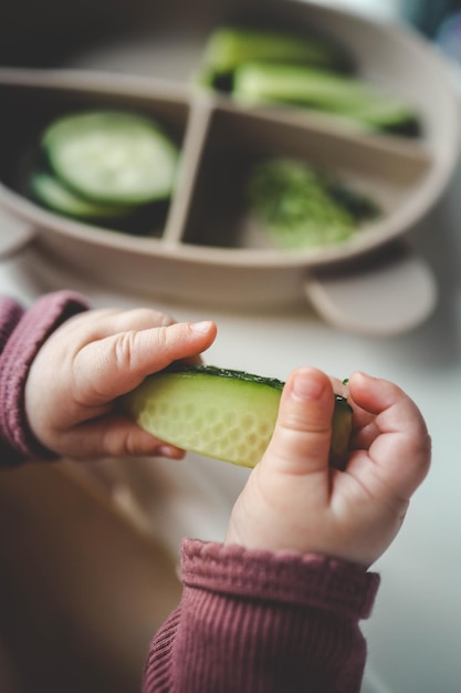 Un niño prueba un pepino usando el método de soplar primero la alimentación