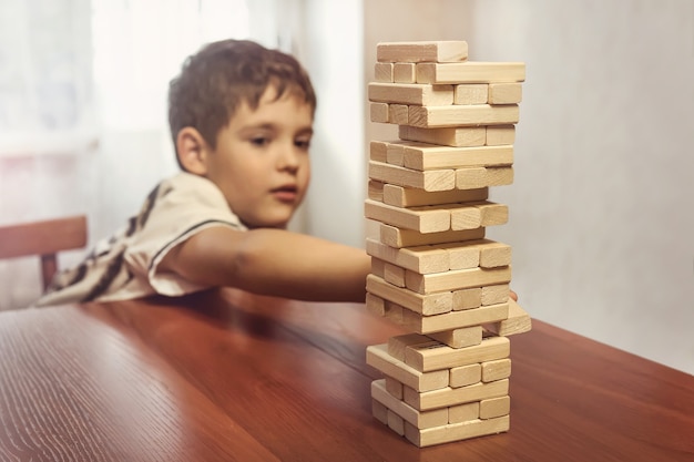 Foto un niño que juega la pila de bloques de madera, el aprendizaje y el concepto de fondo de desarrollo