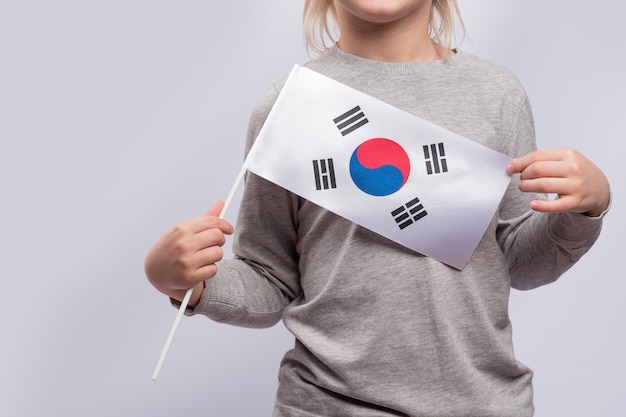 Foto niño que sostiene la bandera de corea del sur