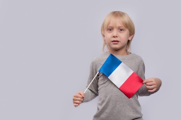 Foto niño que sostiene la bandera de francia