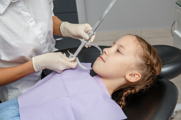 Niño que tiene una cita de ortodoncista en el consultorio del dentista