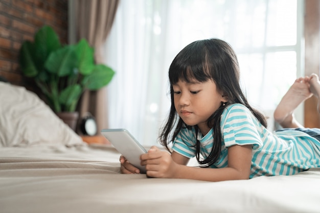 Niño que usa el teléfono inteligente en casa