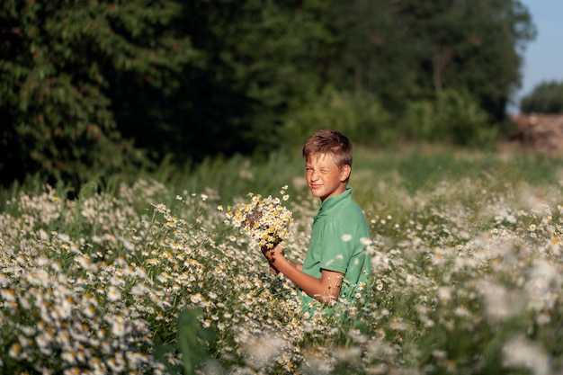 niño con un ramo de flores de manzanilla