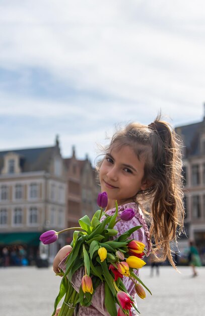 Niño con un ramo de tulipanes en la ciudad Enfoque selectivo