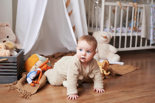 Niño recién nacido de 6 meses sentado y jugando con juguetes educativos. Feliz maternidad y paternidad. Clínica y hospital de maternidad. Día del padre y la madre. El desarrollo de la primera infancia.