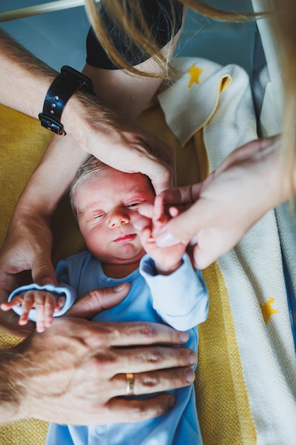 Niño recién nacido en los brazos de su madre y su padre acostado en sus brazos de cerca vista superior Padres jóvenes sostienen a su pequeño bebé Estilo de vida saludable Paternidad