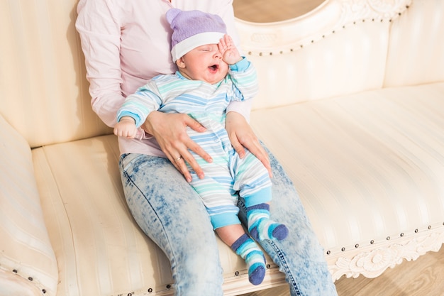 Niño recién nacido cansado frotándose los ojos