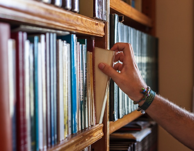 niño recogiendo un libro de un estante