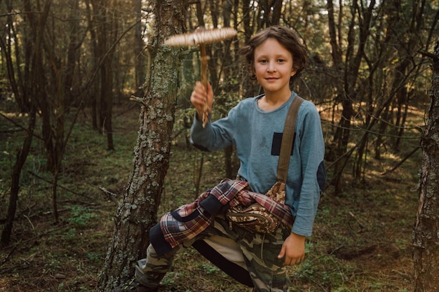 Niño recogiendo setas en el bosque