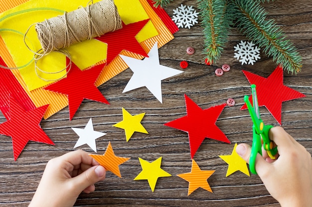 El niño recorta los detalles del árbol de navidad juguetes regalo hecho a mano