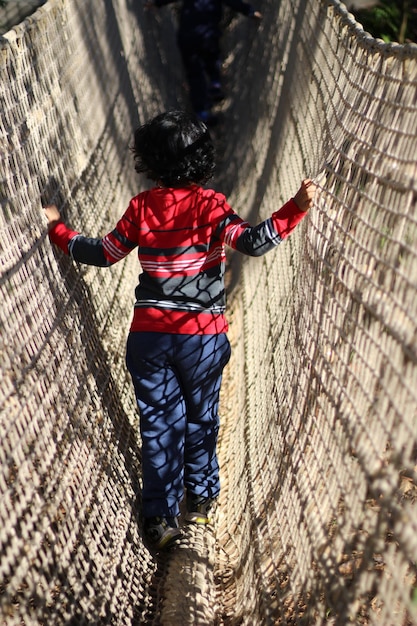 Foto niño en la red del patio de recreo