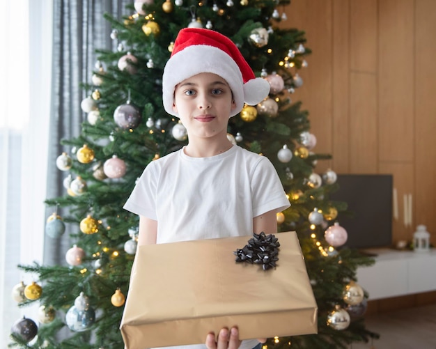 Niño con regalos juega cerca del árbol de Navidad. Interior de la sala de estar con árbol de Navidad y adornos. Año nuevo. Dar regalos.