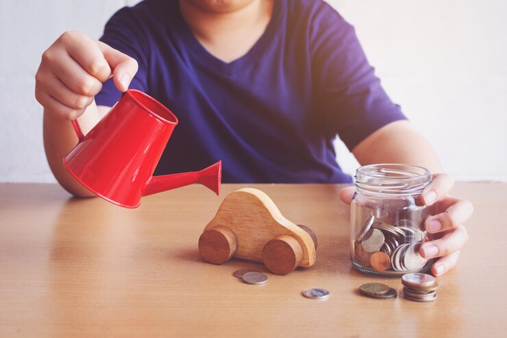 Foto niño regando el coche y las monedas. plan para el concepto de automóvil