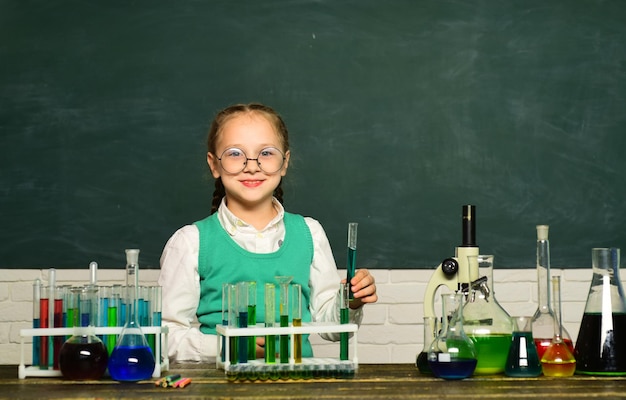 El niño de regreso a la escuela y la educación en el hogar está aprendiendo en clase sobre el fondo de la experiencia en biología de la pizarra ...