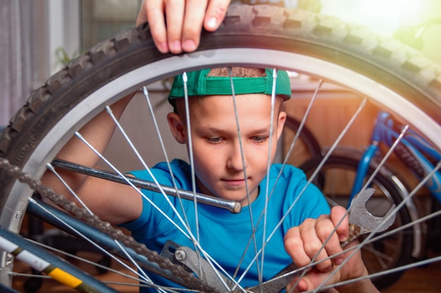 Un niño repara una bicicleta.