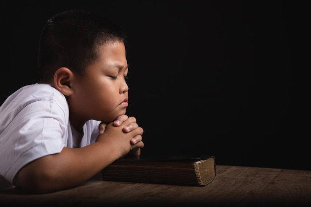 Niño rezando a Dios en casa