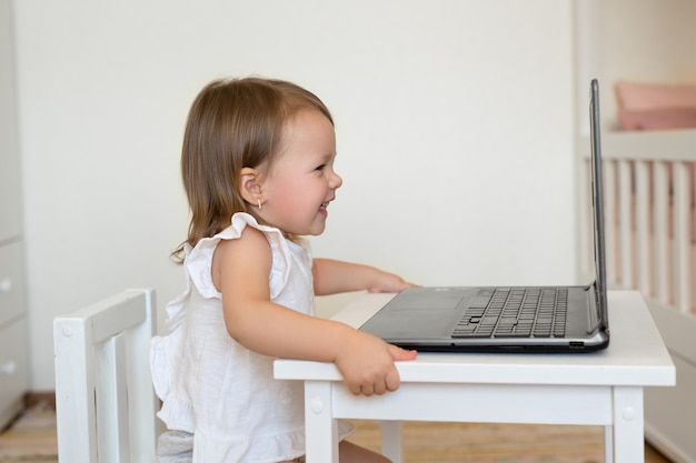 Un niño se ríe durante la comunicación en línea en una computadora portátil.