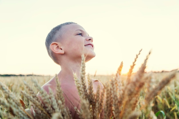 Niño riendo en un campo de trigo al atardecer Cultivo tradicional de pan Primer plano