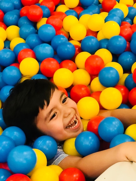 Foto niño riendo jugando con bolas