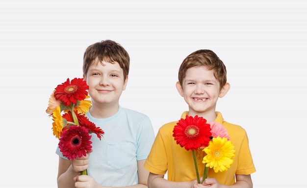 Niño riendo con ramo de flores gerbera.