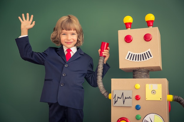 Niño con robot de juguete en la escuela. Concepto de tecnología de éxito e innovación.