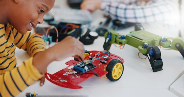 Niño de robótica y tecnología en el aula para la educación o el aprendizaje de electrónica con juguetes de automóviles para la innovación Alumnos escolares y conocimiento de transporte en la clase de ciencias para la investigación o el estudio