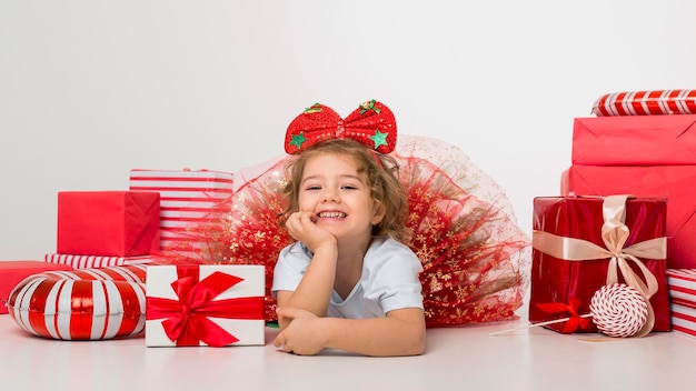 Foto niño rodeado de elementos navideños