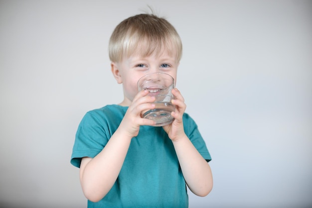 niño rubio bebe agua