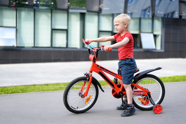 Niño rubio en bicicleta para niños. Urbano