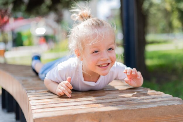 Un niño rubio feliz jugando en un pueblo infantil en un día de verano foto de alta calidad