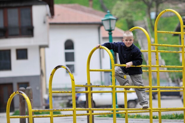 niño rubio joven feliz diviértase y juegue juegos al aire libre en el parque