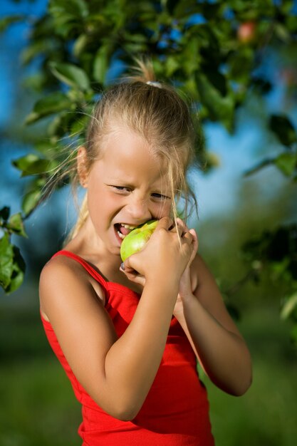 niño rubio mordiendo la manzana