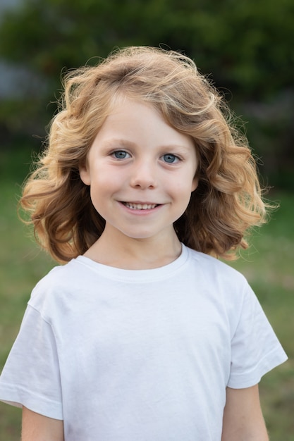 Niño rubio con el pelo largo al aire libre