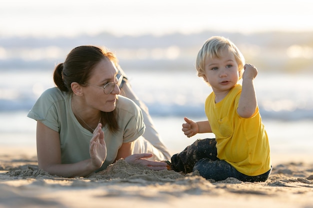 Niño rubio y su madre jugando en la playa