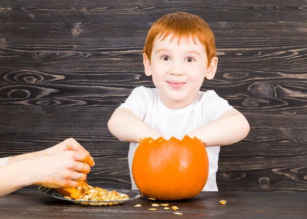 niño saca de las semillas de calabaza cortadas