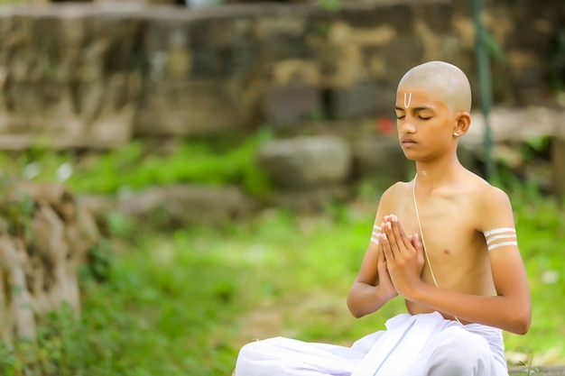 El niño sacerdote indio haciendo meditación