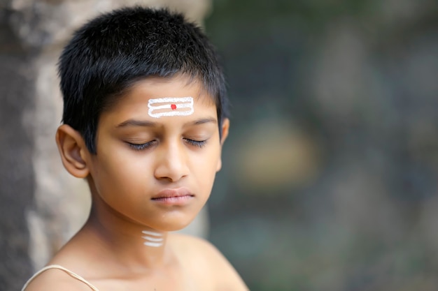 El niño sacerdote indio haciendo meditación