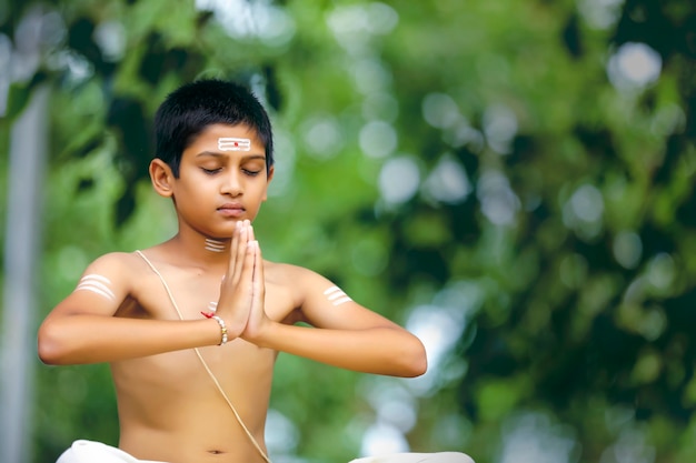 El niño sacerdote indio haciendo meditación