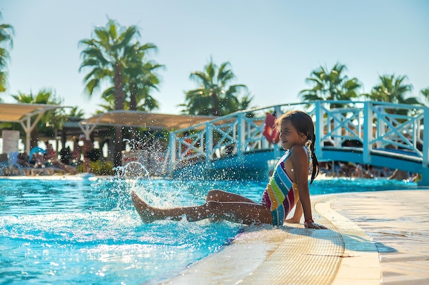 El niño salpica sus pies cerca de la piscina. Enfoque selectivo. Niño.