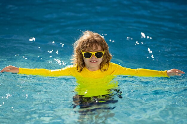 Foto niño salpicándose en la piscina de agua de verano niño salpicando en la piscina emocionado niño pequeño feliz saltando en la alberca