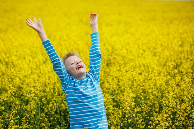 Niño saltando de alegría en un prado en un día soleado