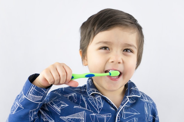 Niño sano que limpia sus dientes con la cara sonriente