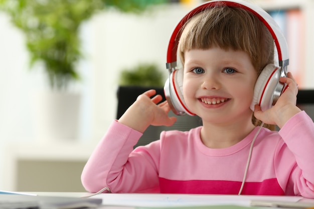 Niño satisfecho en auriculares sentado