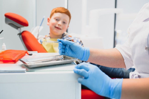 Niño satisfecho con el servicio en el consultorio dental. concepto de tratamiento dental pediátrico