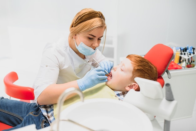 Niño satisfecho con el servicio en el consultorio dental. concepto de tratamiento dental pediátrico