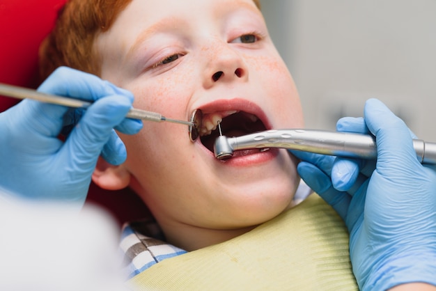 Niño satisfecho con el servicio en el consultorio dental. concepto de tratamiento dental pediátrico