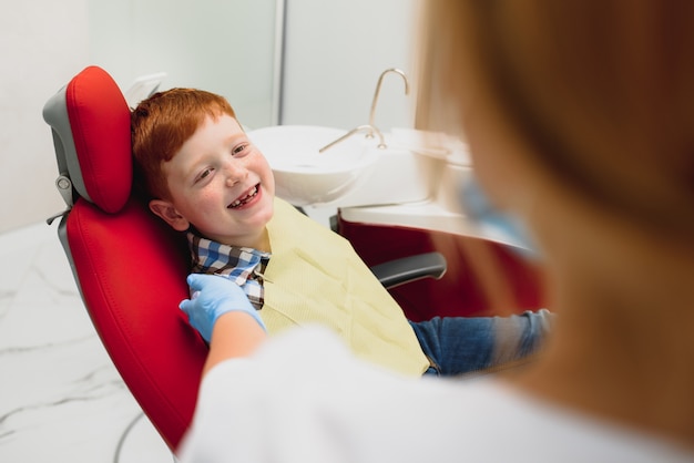 Niño satisfecho con el servicio en el consultorio dental. concepto de tratamiento dental pediátrico